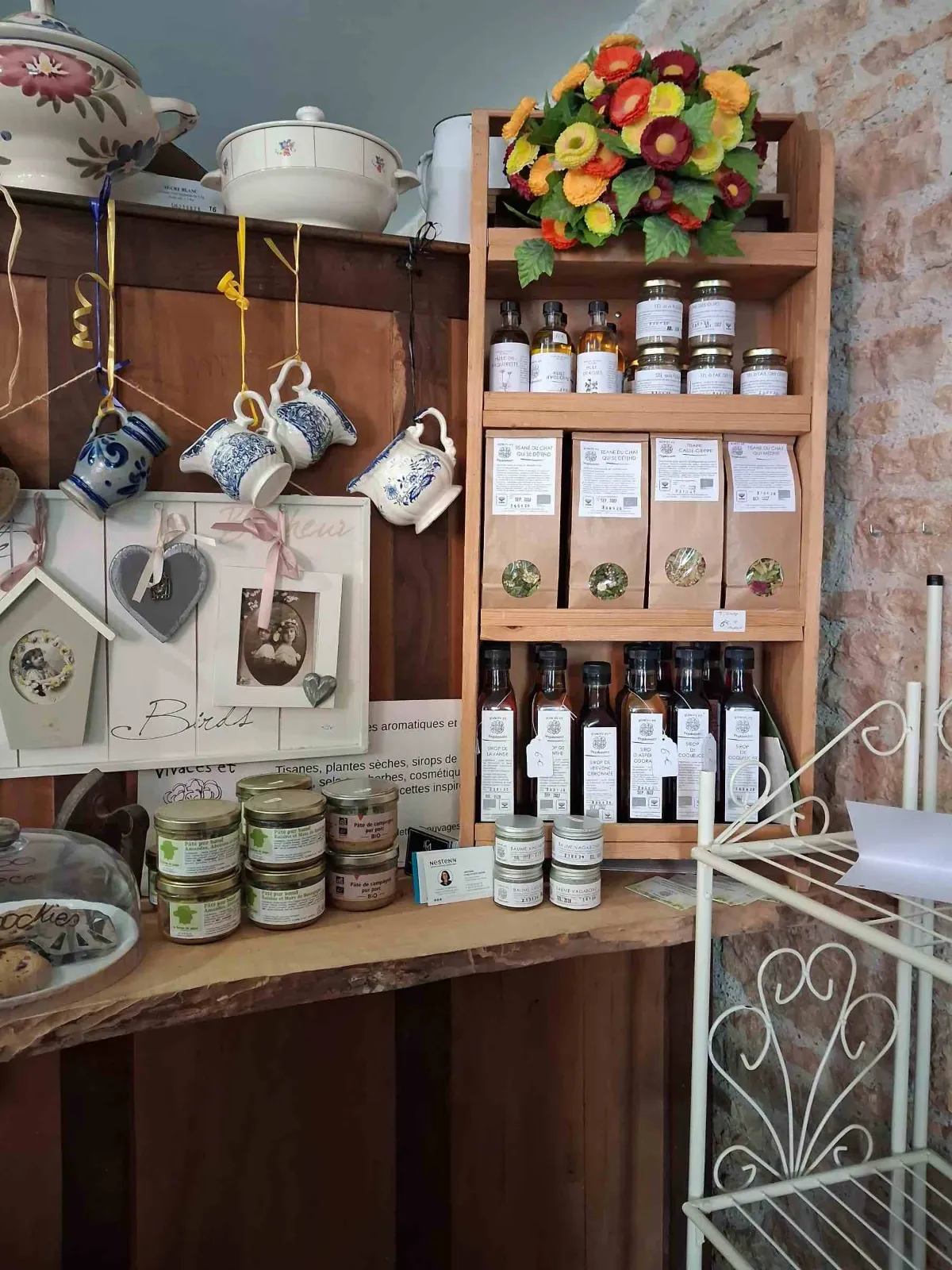 Tisanes, sirops et terrines de producteurs sur l'étagère en bois